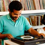 아날로그 기술의 발전 - **Prompt:** A cozy Portuguese living room bathed in warm, soft afternoon light. A diverse group of y...